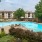 Fenced-in pool with lounge chairs around